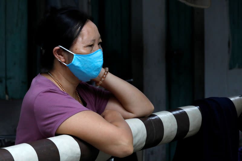 Woman wearing a protective mask is seen inside a quarantined hamlet with a house of a coronavirus disease (COVID-19) patient in Hanoi