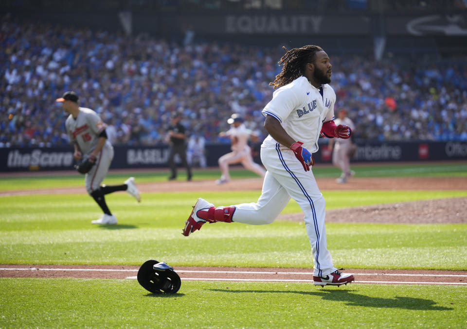 Toronto Blue Jays' Vladimir Guerrero Jr.'s (27) helmet flies off his head as he runs to first base on his RBI single against the Baltimore Orioles during the sixth inning of a baseball game in Toronto, Thursday Aug. 3, 2023. (Mark Blinch/The Canadian Press via AP)