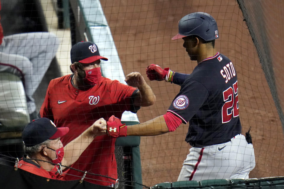 Washington Nationals' Juan Soto, right, is greeted in the dugout after hitting a two-run home run off Baltimore Orioles starting pitcher Asher Wojciechowski during the fourth inning of a baseball game, Saturday, Aug. 15, 2020, in Baltimore. Nationals' Adam Eaton scored on the home run. (AP Photo/Julio Cortez)