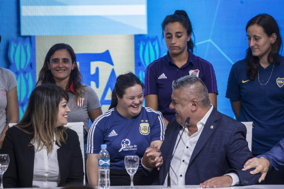 Claudio Tapia, president of Argentina's Soccer Federation, greets a soccer player during a press conference to announce the early implementation of a plan to professionalize women's soccer in Buenos Aires, Argentina, Saturday, March 16, 2019. Almost 90 years after men's soccer turned professional in Argentina, the women's game is still being played by amateur athletes who get little to no money for their work on the field. (AP Photo/Daniel Jayo)