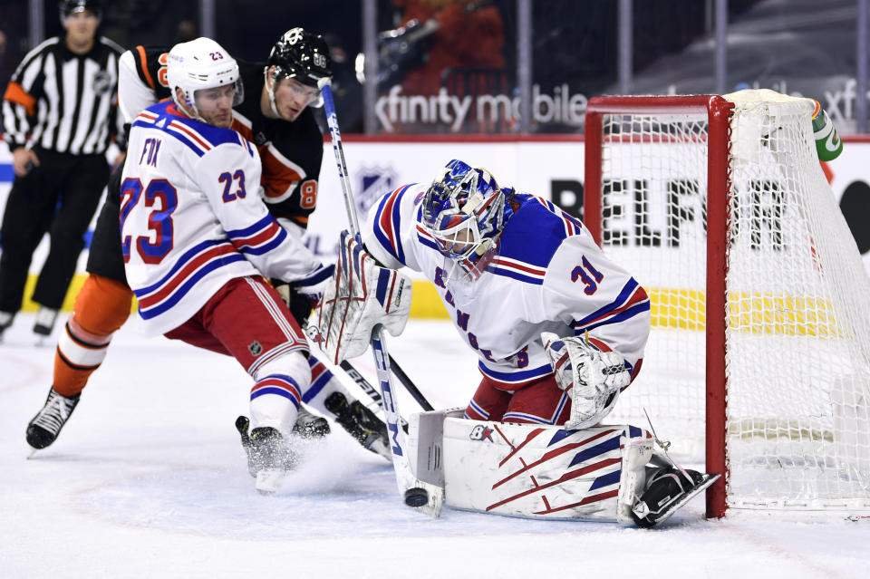 New York Rangers goaltender Igor Shesterkin makes a save as Adam Fox (23) and Philadelphia Flyers' Joel Farabee crash the net during the first period of an NHL hockey game, Saturday, March 27, 2021, in Philadelphia. (AP Photo/Derik Hamilton)