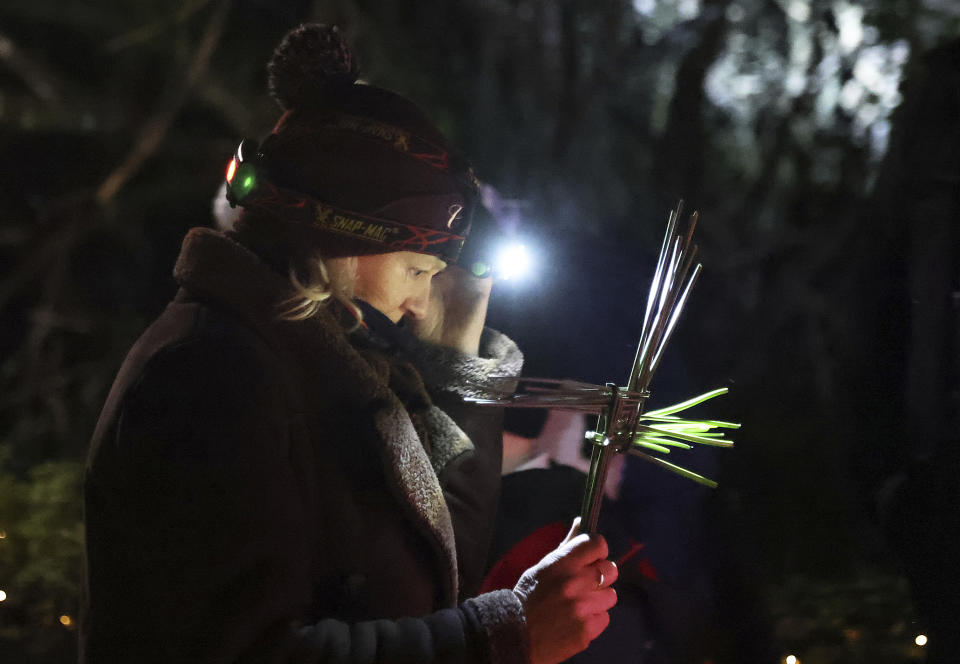 A woman holds a St. Brigid Cross as she participates in a candlelight pilgrimage walk, which makes its way past an ancient well associated with St Brigid, to the Solas Bhride Centre in Kildare, Ireland, Tuesday, Jan. 31, 2023. St. Brigid of Kildare, a younger contemporary of St. Patrick, is quietly and steadily gaining a following, in Ireland and abroad. Devotees see Brigid, and the ancient Irish goddess whose name and attributes she shares, as emblematic of feminine spirituality and empowerment. (AP Photo/Peter Morrison)