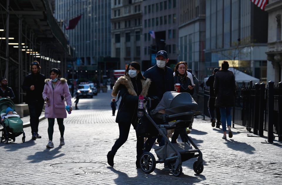 People walk past the New York Stock Exchange (NYSE) at Wall Street on November 16, 2020 in New York City. - Wall Street stocks rose early following upbeat news on a coronavirus vaccine and merger announcements in the banking and retail industries. (Photo by Angela Weiss / AFP) (Photo by ANGELA WEISS/AFP via Getty Images)