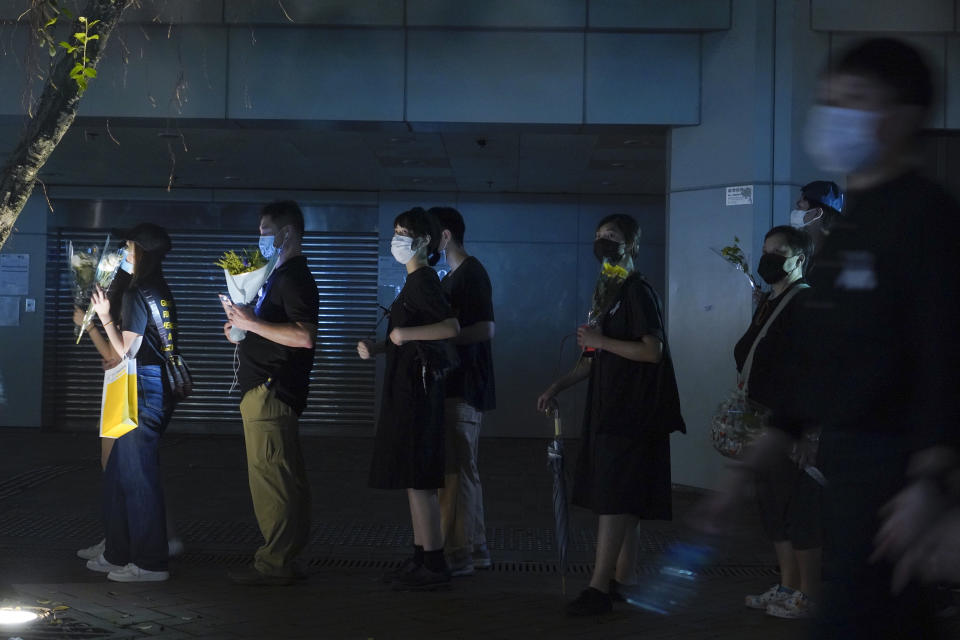 Mourners lay flowers as they pay respect on the site to mark the one year anniversary where a man fell to his death after hanging a protest banner against the extradition bill on a building scaffolding in Hong Kong Monday, June 15, 2020. Protesters in Hong Kong got the government to withdraw extradition legislation last year, but now they're getting a more dreaded national security law, and the message from Beijing is that protest is futile. (AP Photo/Vincent Yu)