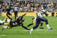 Seattle Seahawks running back Travis Homer (25) gets past diving Pittsburgh Steelers cornerback Joe Haden (23) in the first half of an NFL football game, Sunday, Oct. 17, 2021, in Pittsburgh. (AP Photo/Fred Vuich)