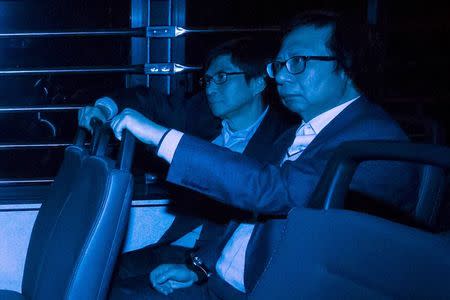 Former Sun Hung Kai Properties executive Thomas Chan, and Thomas Kwok (R), former co-chairman of Sun Hung Kai Properties, sit in a prison van as they leave the High Court in Hong Kong December 22, 2014. REUTERS/Tyrone Siu