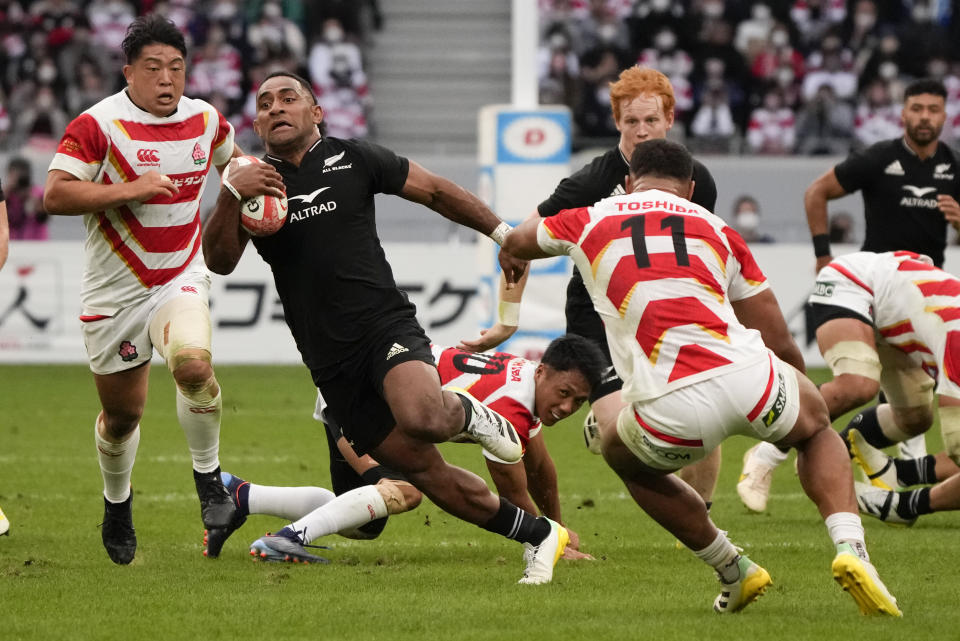 New Zealand's Sevu Reece, centre, runs past Japan's Siosaia Fifita to score a try during the rugby international between the All Blacks and Japan at the National Stadium in Tokyo, Japan, Saturday, Oct. 29, 2022. (AP Photo/Shuji Kajiyama)