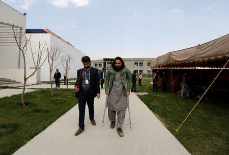 Rahmatullah Amiri, (R) a political science student of American University of Afghanistan who was injured in last year's attack, arrives for new orientation sessions at a American University in Kabul. REUTERS/Mohammad Ismail