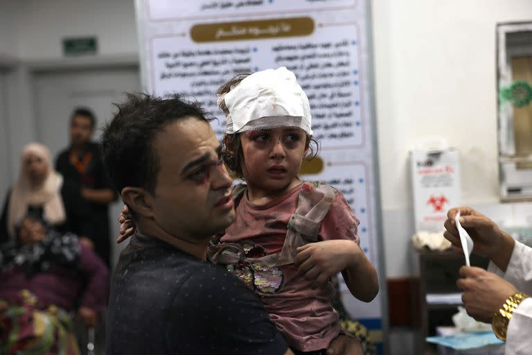 Un palestino lleva a su hija herida al hospital de Najjar tras un ataque aéreo israelí contra una vivienda en Rafah.