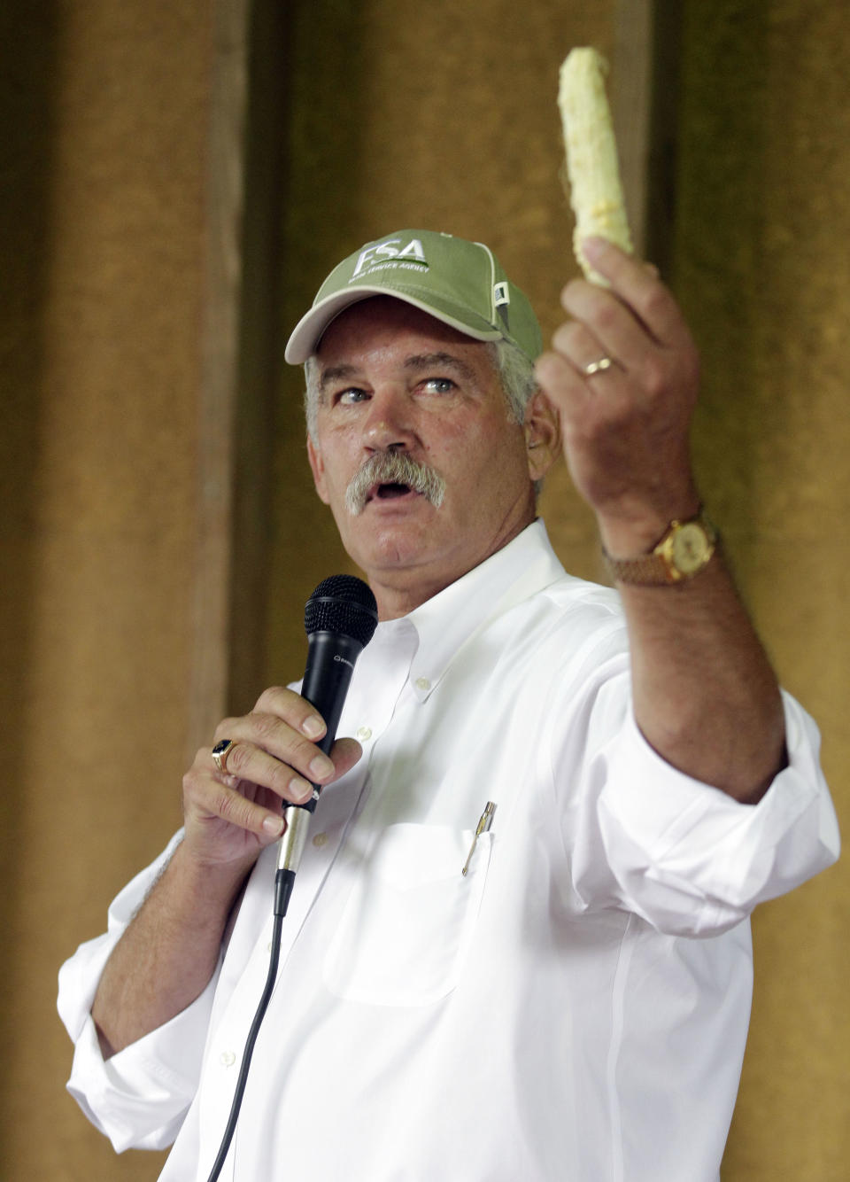 USDA Farm and Foreign Agricultural Services Undersecretary Michael Scuse displays a drought damaged ear of corn as he talks with local farmers and producers as he toured drought disaster areas in Whiteland, Ind., Thursday, July 19, 2012. The new U.S. Drought Monitor report released Thursday says almost 54 percent of Indiana is in extreme drought, a situation that experts say will take weeks of regular rainfall to relieve. (AP Photo/Michael Conroy)