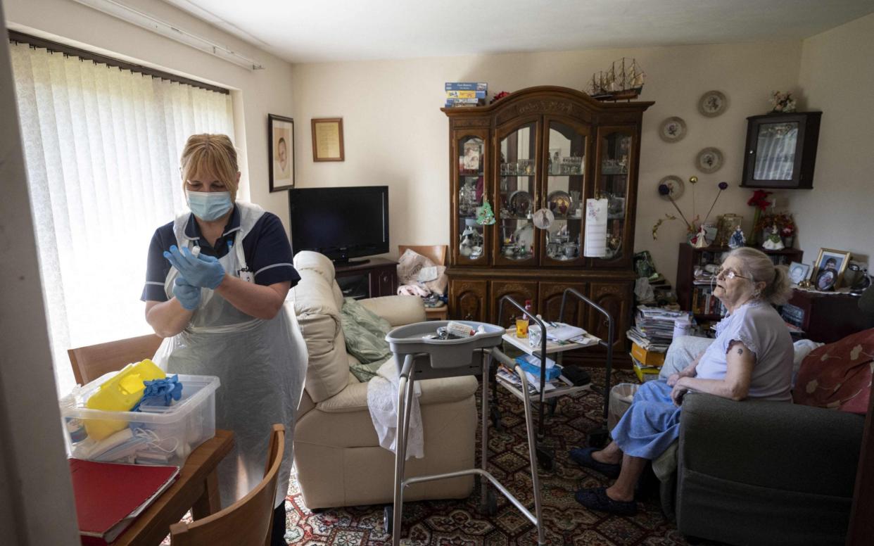 Julie Fletcher prepares to administer the AstraZeneca vaccine to housebound patient Hazel Usher at her home in Hasland, near Chesterfield - Oli Scarff/AFP