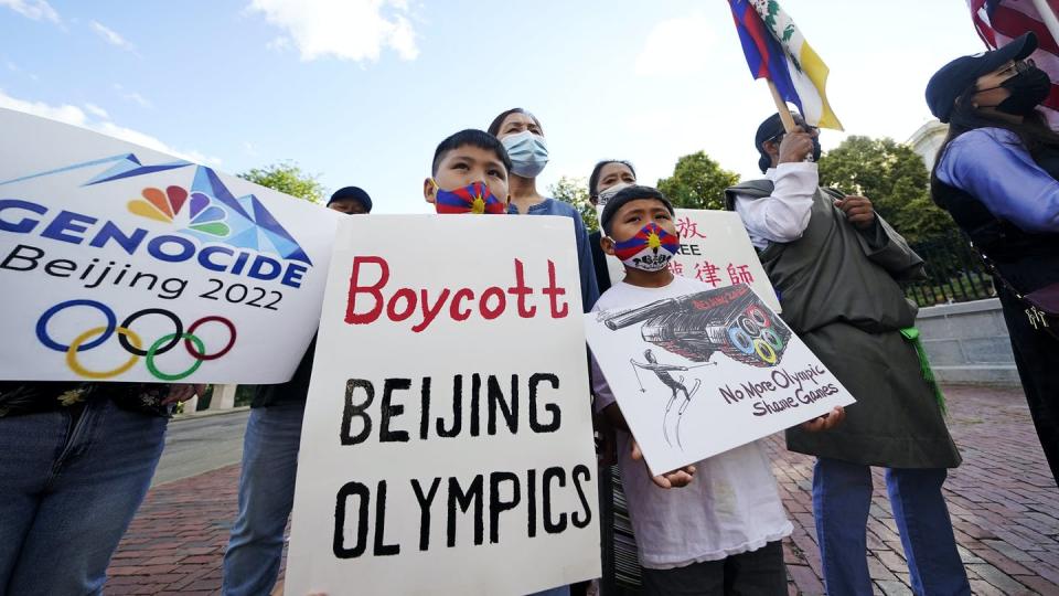 Group of people holding protest signs that say 'Boycott Beijing Olympics' and 'Genocide Beijing 2022.'