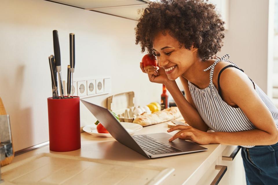 A person staring at their laptop with excitement after buying an insurance policy online.