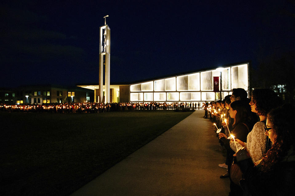 In this April 2, 2017 photo released by Sacred Heart University, students participate in a candlelight vigil in memory of student Caitlin Nelson on the school's campus in Fairfield, Conn. Police said Nelson, from Clark, N.J., died days after choking during a pancake-eating contest at the college. (Sean Kaschak/Sacred Heart University via AP)