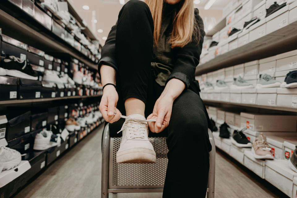 a person tying their shoes in a shoe store