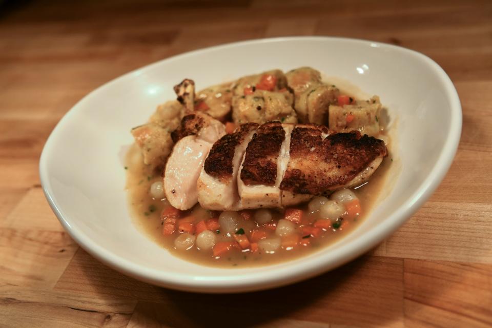 The chicken and dumplings at Elkmont station consist of a sliced chicken breast flanked by dumplings with more of a dressing-like texture, all on a bed of gravy with carrots and onions.