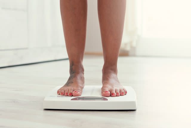 <p>Getty</p> Person weighs themselves on a scale.