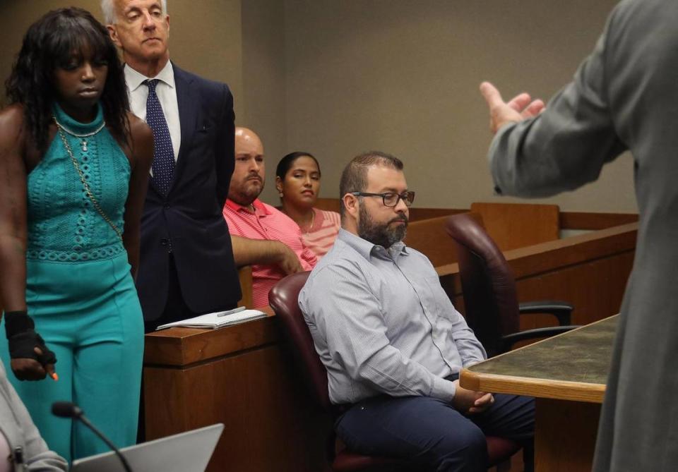 Alejandro Giraldo, right, the former Miami-Dade cop who was convicted of unlawfully tackling Dyma Loving, left, to the ground and then writing a false arrest report, sits quietly as she is gestured give a statement by the prosecutor in courtroom 6-4 during Giraldo’s sentencing on Tuesday, June 22, 2022 at the Richard E. Gerstein Justice Building in Miami, Florida.