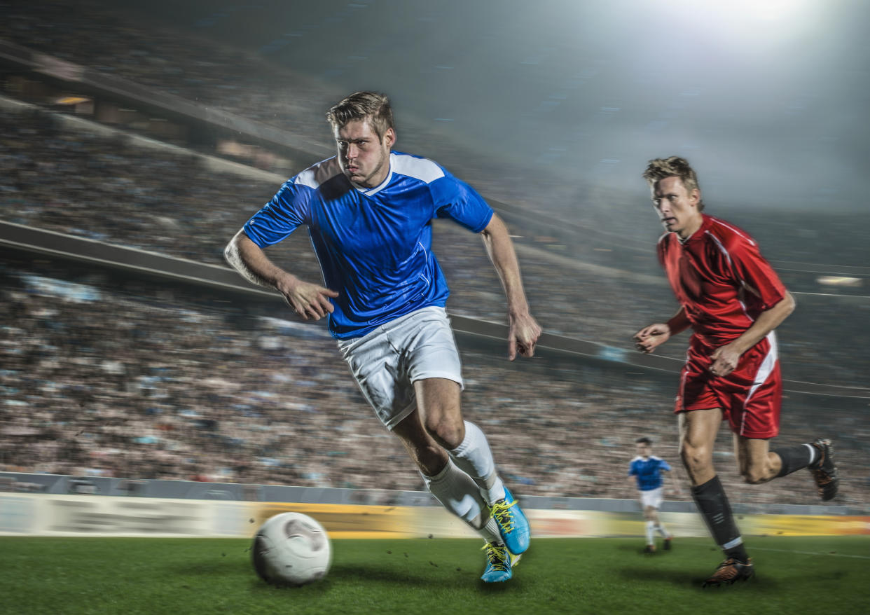 Football player running with ball in stadium