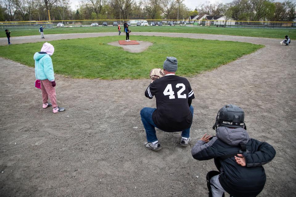 Monarchs' catcher Jorden Daniel, 9, stands behind coach Pete Schneider to learn catching at practice at Stoepel Park in Detroit on Tuesday, April 25, 2023.