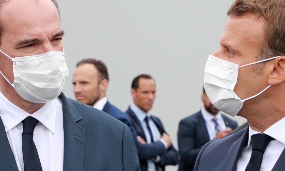 Emmanuel Macron (right) and French prime minister, Jean Castex, both wearing a protective facemasks speak at the end of the annual Bastille Day military ceremony.