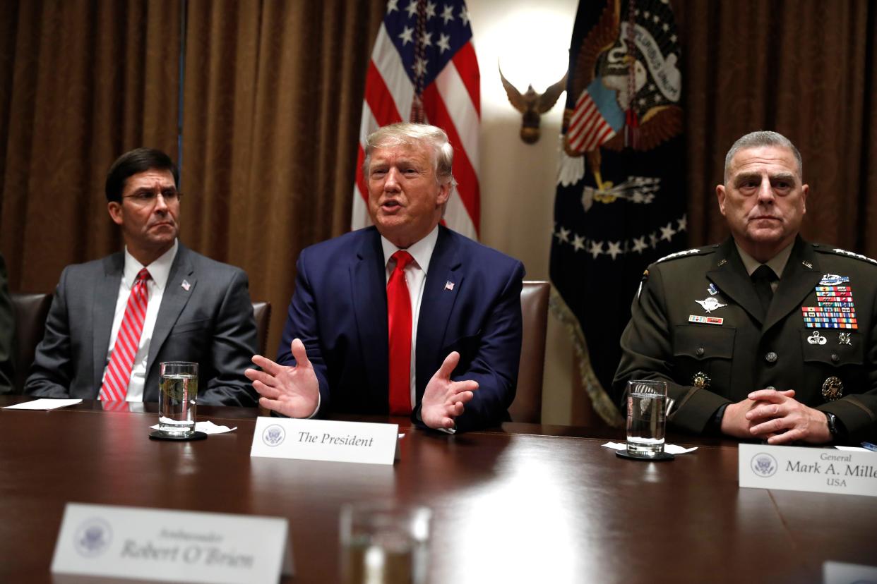 Then-President Donald Trump (center) speaks as the Chairman of the Joint Chiefs of Staff Gen. Mark Milley (right) and Defense Secretary Mark Esper (left) listen during a briefing with senior military leaders in the Cabinet Room at the White House in Washington, D.C. on Monday, Oct. 7, 2019. 
