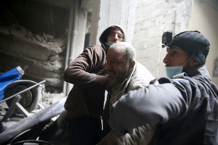 Civil defence help a man from a shelter in the besieged town of Douma in eastern Ghouta in Damascus, Syria, February 22, 2018. REUTERS/Bassam Khabieh