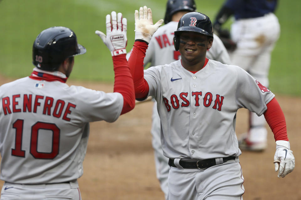 Boston Red Sox Rafael Devers (11) high fives teammate Boston Red Sox Hunter Renfroe (10) after hitting a home run against the Minnesota Twins during the ninth inning of a baseball game, Tuesday, April 13, 2021, in Minneapolis. Boston won 4-2. (AP Photo/Stacy Bengs)