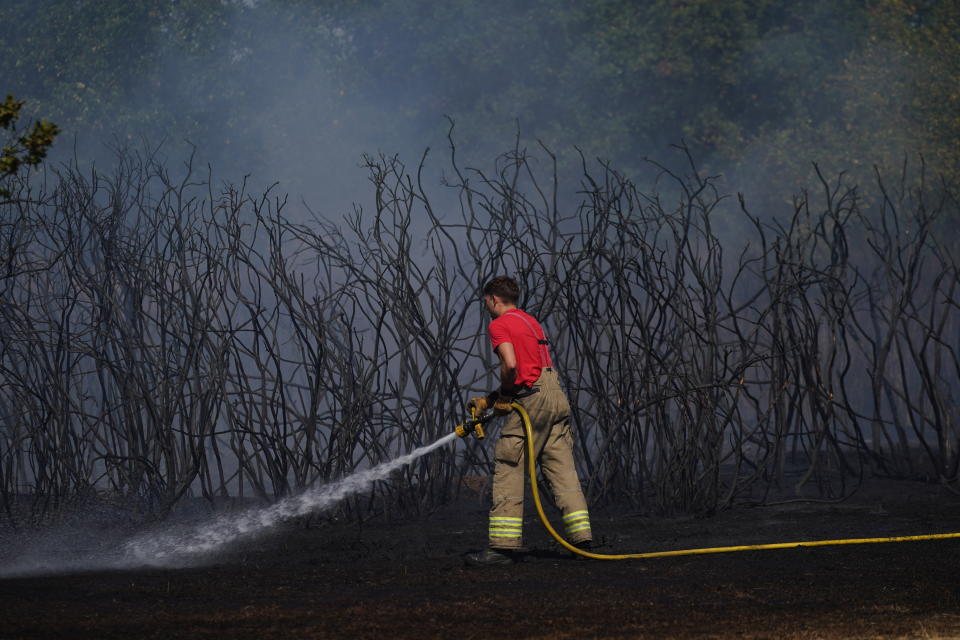 A firefighter dampens down a grass fire on Leyton flats in east London, as a drought has been declared for parts of England following the driest summer for 50 years.