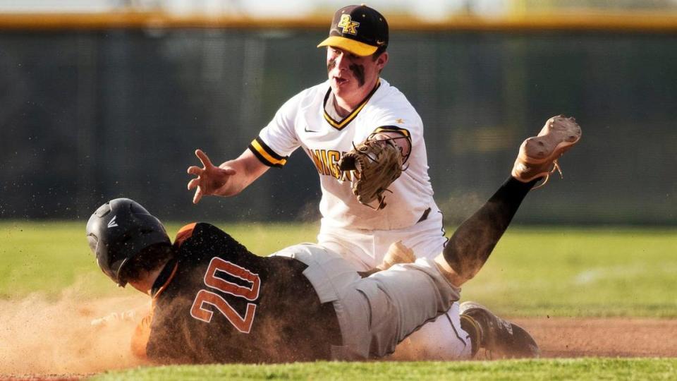 Bishop Kelly third baseman Hadley Smith tags out Ridgevue’s Nathan Rice in the 4A District Three baseball championship Thursday at Vallivue High School in Caldwell.