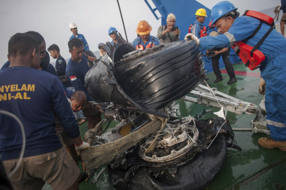 Rescuers inspect part of the landing gears of the crashed Lion Air jet they retrieved from the sea floor in the waters of Tanjung Karawang, Indonesia, Sunday, Nov. 4, 2018. Investigators succeeded in retrieving hours of data from the aircraft's flight recorder as Indonesian authorities on Sunday extended the search at sea for victims and debris. (AP Photo/Fauzy Chaniago)