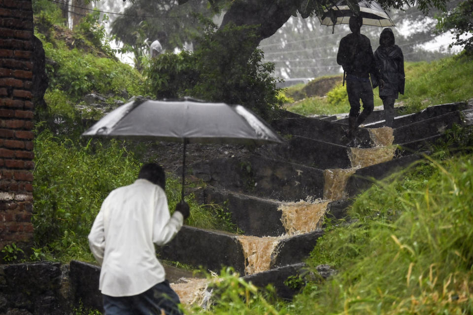 Varias personas se protegen de las lluvias causadas por el ciclón Freddy, en Blantyre, Malawi, el 14 de marzo de 2023. (AP Foto/Thoko Chikondi)