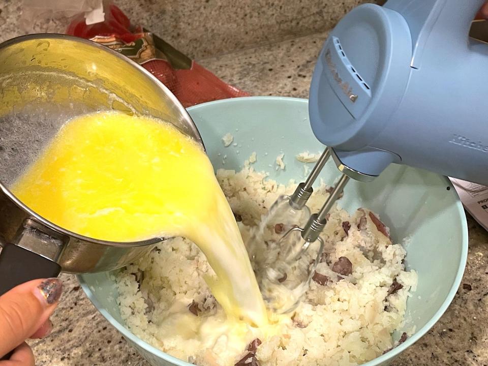 Pouring butter into potatoes for Ina Garten's smashed potatoes