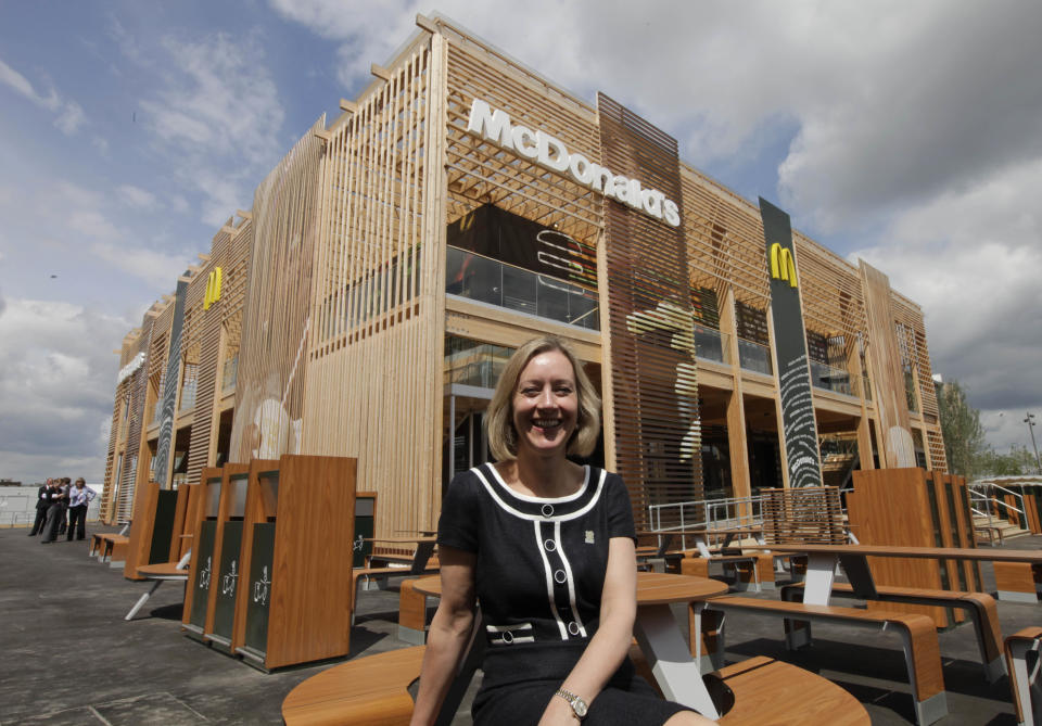 Jill McDonald, CEO of McDonald's UK, backdropped by the newly constructed McDonald's restaurant at the Olympic Park, poses for the photographers in east London, Monday, June 25, 2012. The restaurant is designed to be reusable and recyclable after the London 2012 Olympic and Paralympic Games. (AP Photo/Lefteris Pitarakis)