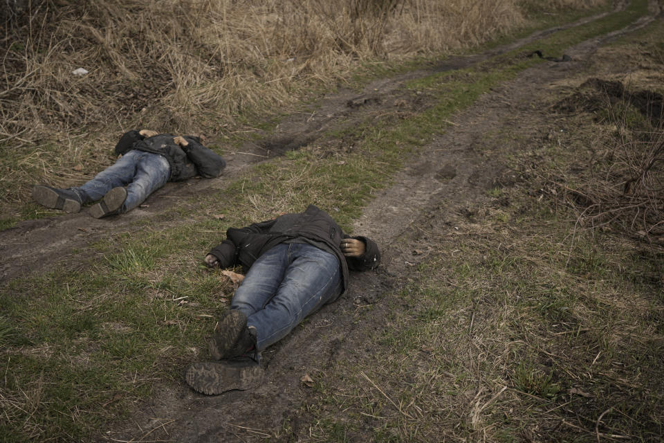 The lifeless bodies of two men lie on a dirt path in Bucha, Ukraine, Monday, April 4, 2022. Russia faced a fresh wave of condemnation on Monday after evidence emerged of what appeared to be deliberate killings of civilians in Ukraine. Some Western leaders called for further sanctions in response, even as Moscow continued to press its offensive in the country's east. (AP Photo/Vadim Ghirda)