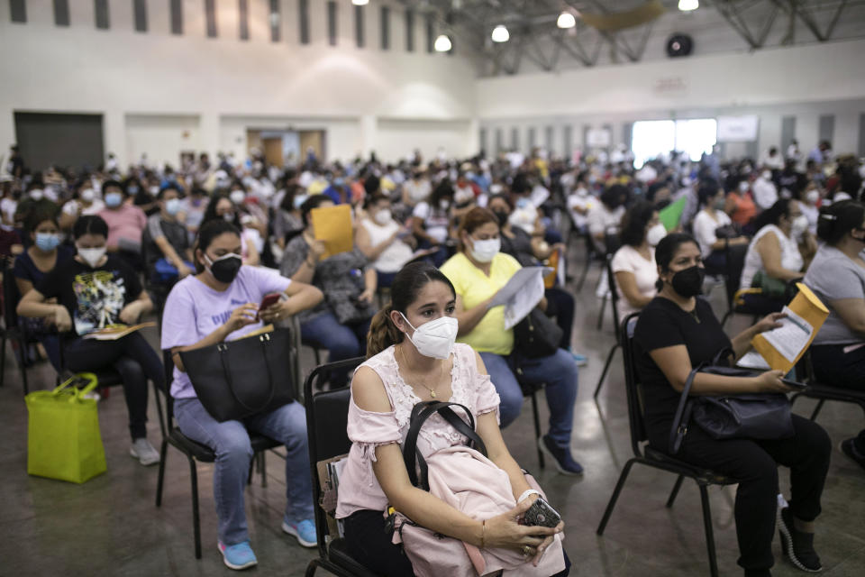 Education workers wat for their jab of the single-dose CanSino COVID-19 vaccine during a vaccination drive at the World Trade Center in Boca del Rio, Veracruz state, Mexico, Tuesday, April 20, 2021. The Mexican government began giving teachers in five other states the single-dose CanSino COVID-19 vaccine to speed up their return to the classroom before the end of the school year in July. (AP Photo/Felix Marquez)