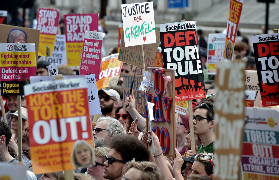 <p>A demonstrator holds a placard reading “Justice 4 Grenfell”, relating to the June 14 fire at Grenfell Tower, during an anti-Conservative Party Leader and Britain’s Prime Minister Theresa May, and Democratic Unionist Party (DUP) protest, on Whitehall, oppostite the enntrance to Downing Street in central London on June 17, 2017.<br> (Chris J. Ratcliffe/AFP/Getty Images) </p>