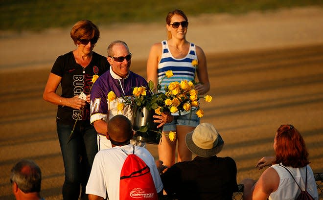 Driver David Miller hands out roses after winning the Little Brown Jug in 2016.