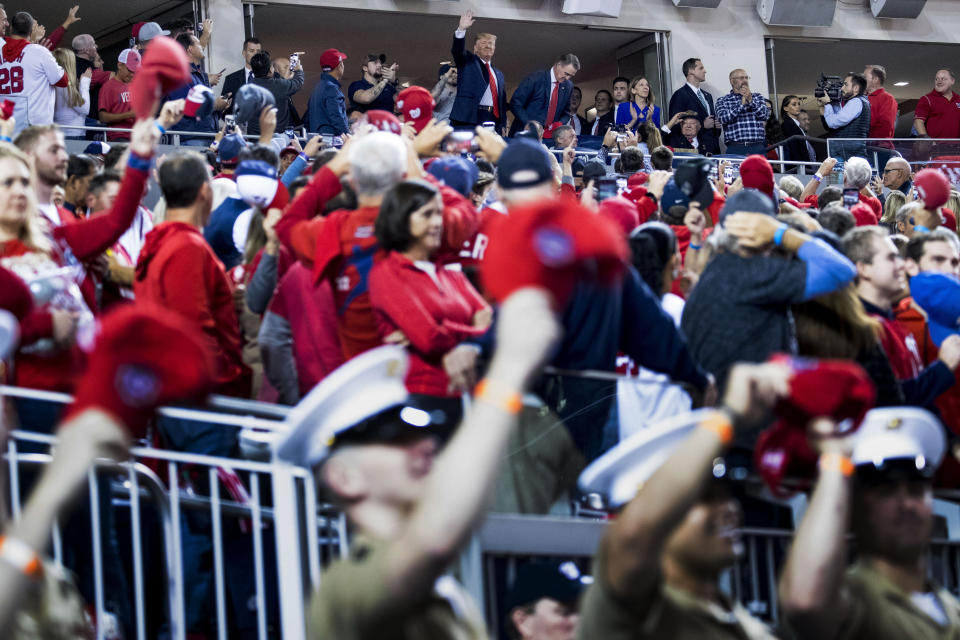 President Donald Trump, top center, stands and applauds as members of the military, foreground, are recognized during Game 5 of a baseball World Series between the Houston Astros and the Washington Nationals at Nationals Park in Washington, Sunday, Oct. 27, 2019. (AP Photo/Andrew Harnik)