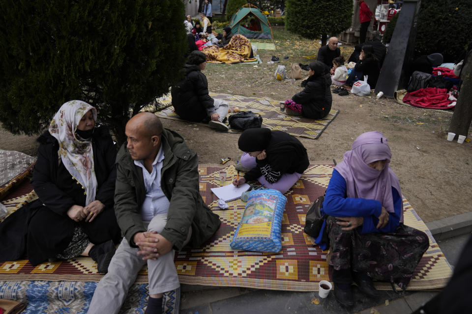 People rest outside their homes in Duzce, Turkey, Wednesday, Nov. 23, 2022, after a magnitude 5.9 earthquake hit a town in northwest Turkey early Wednesday, causing damage to some buildings and widespread panic. At least 68 people were injured, mostly while trying to flee homes. The earthquake was centered in the town of Golkaya, in Duzce province, some 200 kilometers (125 miles) east of Istanbul, the Disaster and Emergency Management Presidency said.(AP Photo/Khalil Hamra)