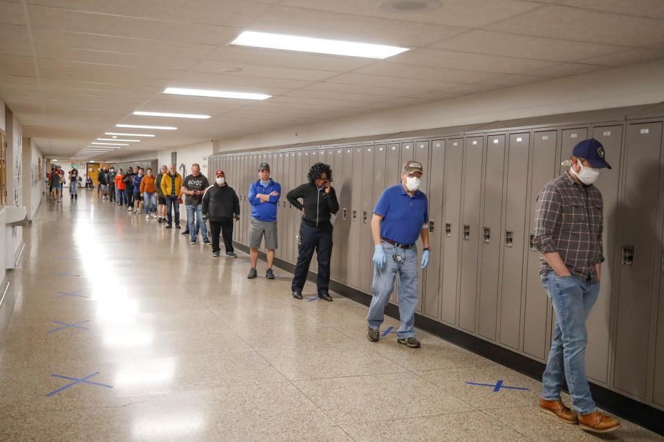 People wait in line to vote in a Democratic presidential primary election outside the Hamilton High School in Milwaukee, Wisconsin, on April 7, 2020. - Americans in Wisconsin began casting ballots Tuesday in a controversial presidential primary held despite a state-wide stay-at-home order and concern that the election could expose thousands of voters and poll workers to the coronavirus. Democratic officials had sought to postpone the election but were overruled by the top state court, and the US Supreme Court stepped in to bar an extension of voting by mail that would have allowed more people to cast ballots without going to polling stations. Both courts have conservative majorities. (Photo by KAMIL KRZACZYNSKI / AFP) (Photo by KAMIL KRZACZYNSKI/AFP via Getty Images)