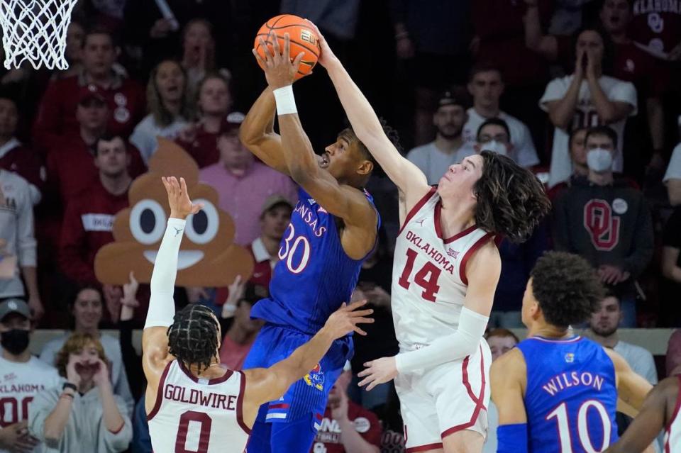 Oklahoma guard Bijan Cortes (14) blocks a shot by Kansas guard Ochai Agbaji in the second half of a game Tuesday, Jan. 18, 2022, in Norman, Okla.