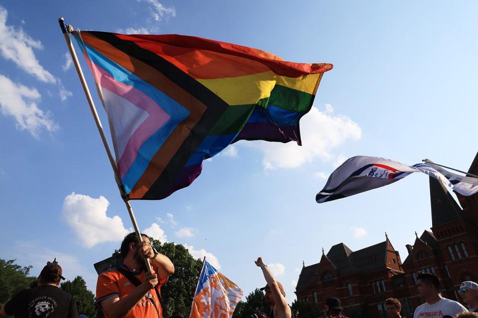 Fans wave pride flags during the march before the match between the New England Revolution and FC Cincinnati at TQL Stadium.