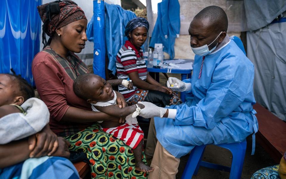 A mother holds her son as he receives his daily injection while being treated for mpox at the Kavumu health center in Kabare territory, South Kivu region, Democratic Republic of Congo