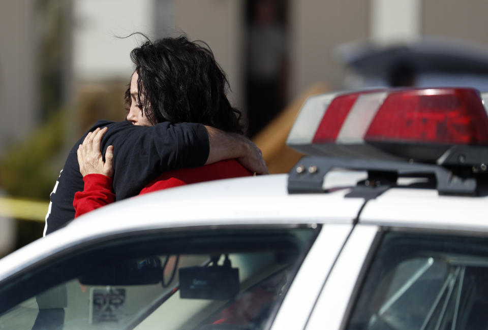 Heidi Fleiss, right, embraces an unknown person outside of the Love Ranch brothel, Tuesday, Oct. 16, 2018, in Pahrump, Nev., where Nevada brothel owner Dennis Hof died. (AP Photo/John Locher)