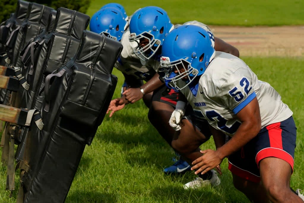 Murrah High School football offensive linemen square up against the blocking sled at practice, Wednesday, Aug. 31, 2022, in Jackson, Miss. (AP Photo/Rogelio V. Solis)