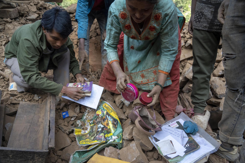 Survivors recover their valuable belongings from earthquake damaged houses in Rukum District, northwestern Nepal, Monday, Nov. 6, 2023. The Friday night earthquake in the mountains of northwest Nepal killed more than 150 people and left thousands homeless. (AP Photo/Niranjan Shrestha)