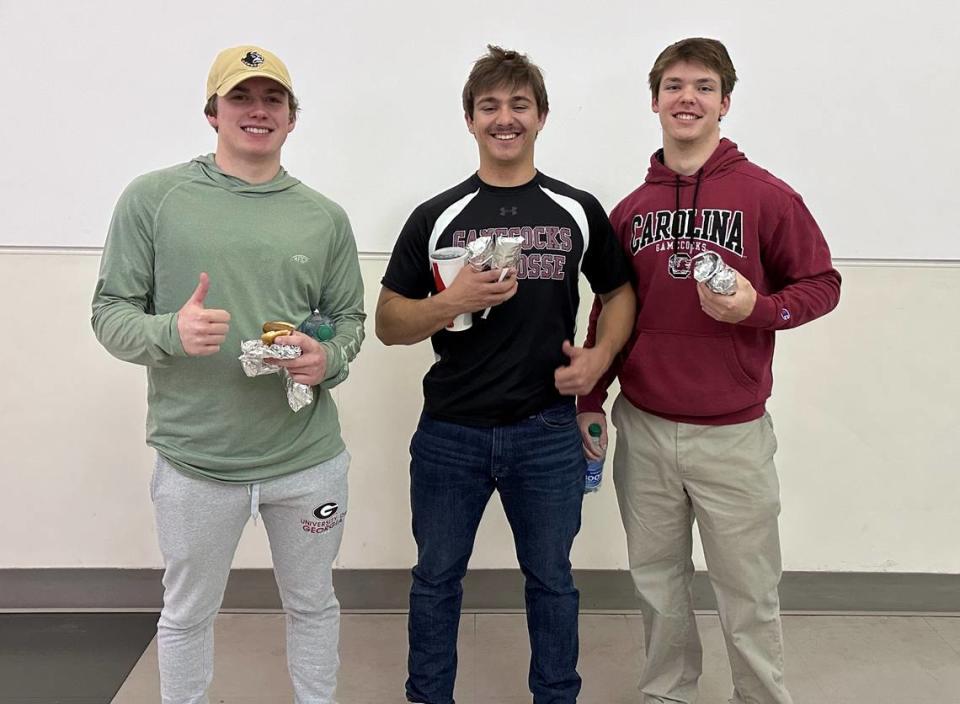 South Carolina fans Jack Hudson, Zach Owens and Andrew Brumgardt with their concession items on Friday.