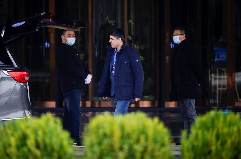 A member of the World Health Organisation (WHO) walks outside his hotel in Wuhan
