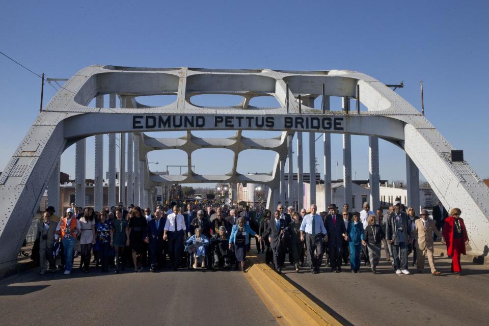 FILE - In this Saturday, March 7, 2015 file photo, President Barack Obama, first lady Michelle Obama, their daughters Malia and Sasha, as well as members of Congress, former President George W. Bush, and civil rights leaders make a symbolic walk across the Edmund Pettus Bridge in Selma, Ala., on the 50th anniversary of "Bloody Sunday," a civil rights march in which protestors were beaten, trampled and tear-gassed by police at the site. The incident led to the passage of the Voting Rights Act in 1965. (AP Photo/Jacquelyn Martin)
